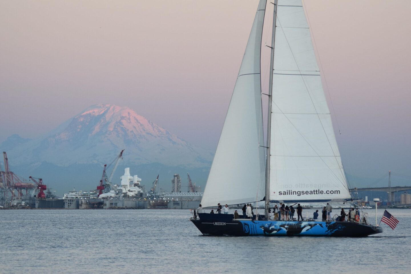 Sailing Seattle Downtown Sail boat at sunset with mount rainier in the background.