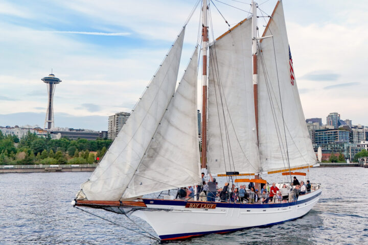 Seattle's Tall Ship sailboat in front of the Space Needle and Seattle skyline.