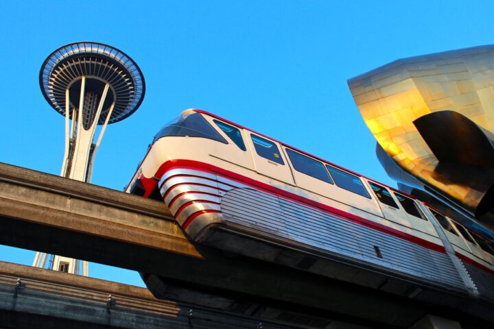 Seattle Monorail Red Train with the Space Needle above and MoPOP to the right.